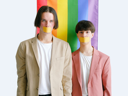 Casal posando com fitas na boca em protesto à repressão da comunidade LGBT