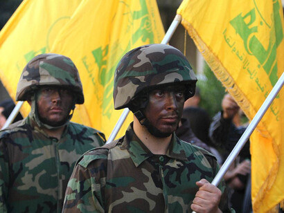 Jóvenes soldaros con la enseña de Hezbollah