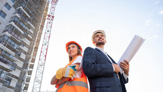 Construction worker and architect collaborating on-site for building project