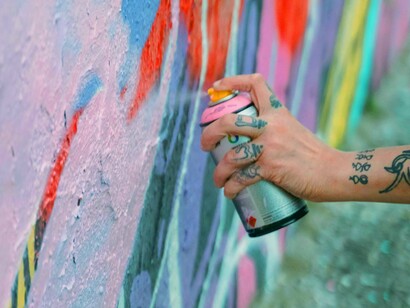 Artista produz seu grafitti. A polícia e a política para inibir a arte das favelas não funcionam. É necessário repensar o papel da política ao redor do “jornalismo do povo”: que tal ler as mensagens e fazer as obras que a periferia necessita? 
