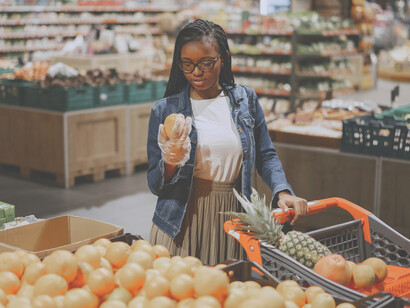 Faced with rows of colorful products, a young woman looks uncertain, struggling to make a decision amid the overwhelming variety