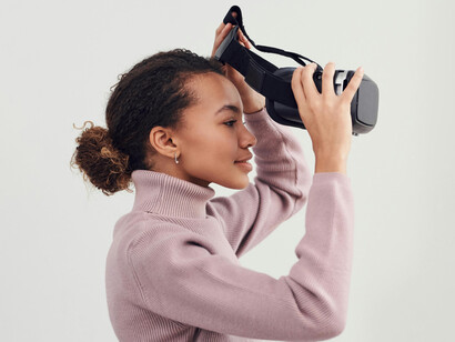 Una joven quítandose los lentes de realidad virtual después de disfrutar su experiencia