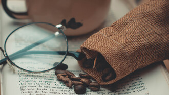 Xícara de café sob a mesa para acompanhar a leitura de um livro