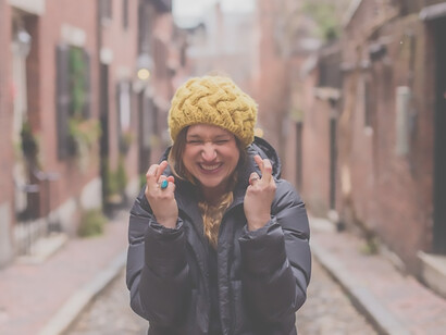 An optimistic woman making a wish with her hands on the road