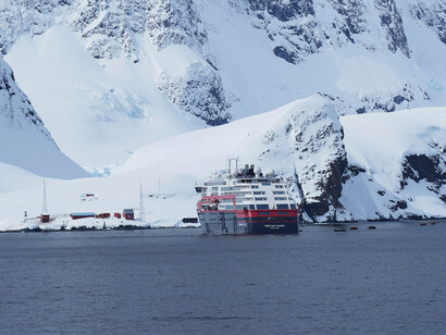 Antarctica—an ice sheet and snowcapped mountains beneath dark, looming clouds