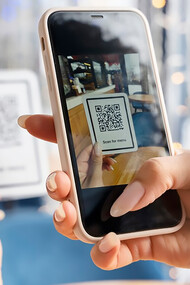 Hands holding phone close up, scanning menu on phone