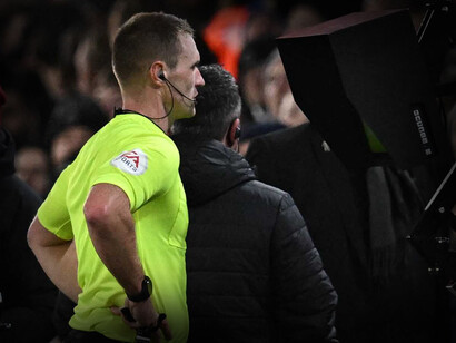 Árbitro profesional de fútbol revisa una jugada en el VAR (Video Assistant Referee)