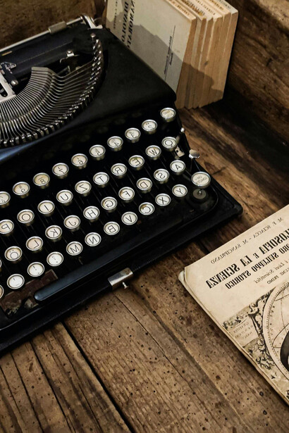 Antiguos libros y una máquina de escribir en un pequeño escritorio