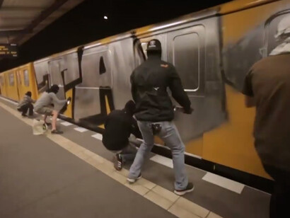 Un grupo de grafiteros cubre de pintura un convoy de metro