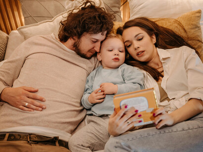 Mãe e pai leem primeira historinha para o filho