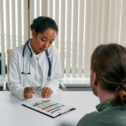 In a quiet clinic, a physician reviews a chart with a patient, underscoring the reality of healthcare inequality in America