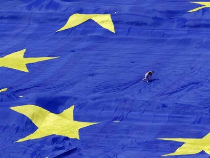 Un bailarín sobre una gran bandera de Europa