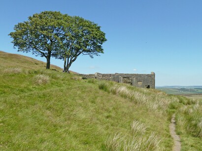 As ruínas de Top Withens destacam-se na paisagem aberta e acidentada dos ermos de Yorkshire. O isolamento desse cenário evoca a atmosfera sombria de Morro dos Ventos Uivantes, onde o ambiente acompanha a intensidade dos conflitos humanos