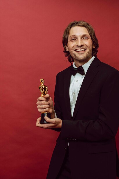 Man smile and poses with his victory cup