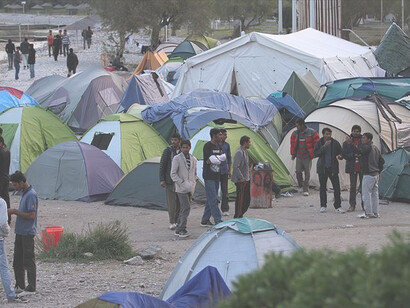 Refugees living in tents at a camp in Greece, highlighting the ongoing humanitarian crisis and the challenges faced by displaced populations