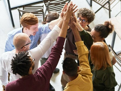Mãos unidas ao centro simbolizam conexão e propósito coletivo. O bem-estar no trabalho começa quando todos se sentem parte de algo maior