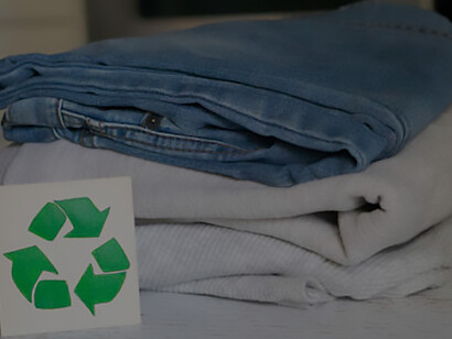 Discover the garment recycling process with a stack of clothes on a recycling table, showcasing the collection for recycling