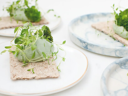 A verdant assortment of fresh green vegetables artfully arranged on a pristine white ceramic plate