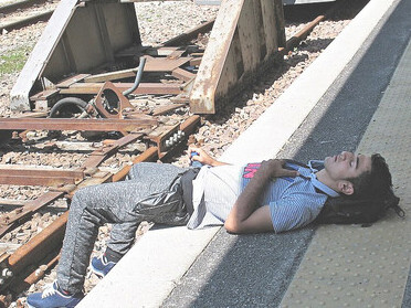 At Brenner train station, June 2015, European migrant crisis: a man lies on the platform during the crisis