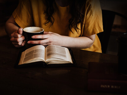 Mujer bebe un café mientras disfruta de una lectura