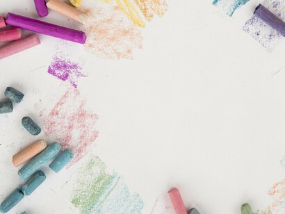 Crayons scattered across the table — traces of a childhood paused, waiting to resume when time runs straight again