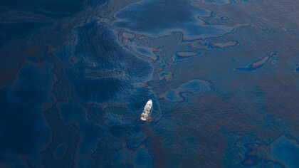A ship floats amongst a sea of spilled oil in the Gulf of Mexico after the BP Deepwater Horizon oilspill disaster