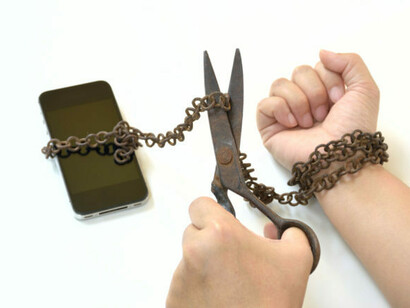 Un gesto simbólico: hombre corta la cadena que lo mantiene atado a su móvil