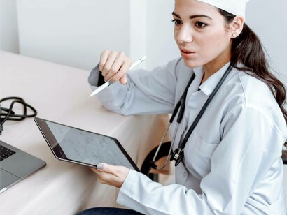 A doctor using her tablet to improve the healthcare of her patient