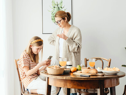 A mother talking to her daughter in a firm tone, representing early conditioning around obedience