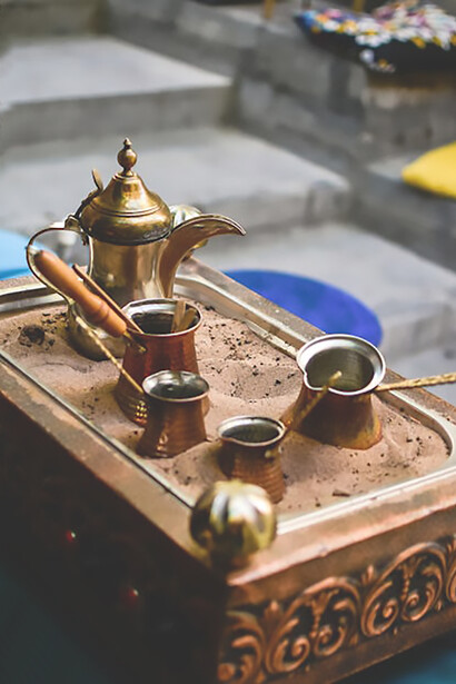 Capture the essence with a captivating image of Turkish coffee brewing in a copper pot on the sand