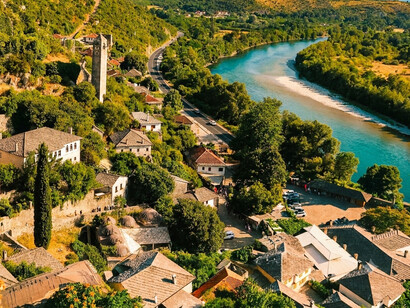 The Osum River tracing a gentle curve through the valley beside Berat’s historic neighborhoods, symbolizing the landscape of Berat, Albania