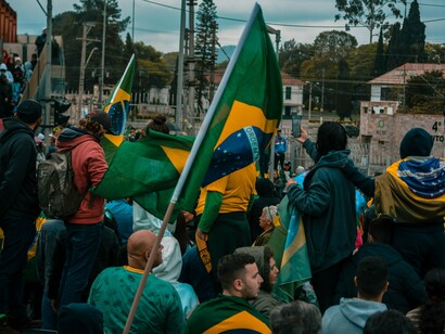 A Brazilian flag flying above a crowd, reflecting the national pride and political divisions shaping Brazil’s election
