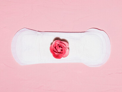 Top view of period essentials: pads, tampons, pain relief, and other menstrual items