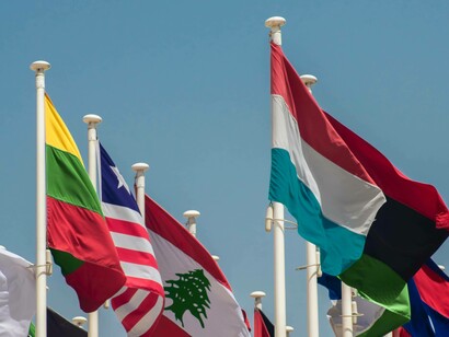 Person zeigt einen 20-Dollar-Schein und eine kleine US-Flagge