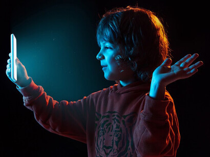 A child engaging in video games, showcasing digital safety measures, combating online child abuse, and AI's contribution to crime preventionA glowing shield rises from a digital network, representing advanced cybersecurity protection in the digital age, emphasizing child protection technology and the role of AI in securing online spaces