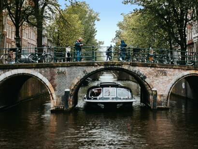 Amsterdã, Holanda. O barco deslizou pelos canais com uma tranquilidade silenciosa, e cada minuto parecia se estender no tempo, como se o ritmo da cidade tivesse se ajustado ao meu próprio