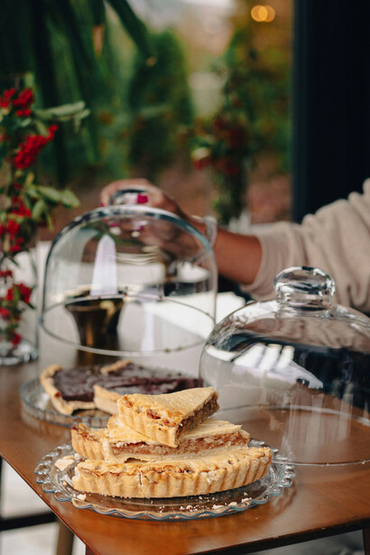 A woman savors cakes at a wine table, indulging in a delightful pairing experience