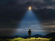 A man looks to the light in the sky