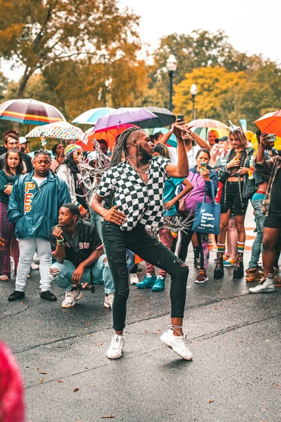 A performer expressing resistance through dance in the rain at a political protest