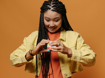 A woman concentrating on a Rubik's Cube, representing the importance of challenging the mind as part of overall health