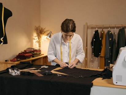 Profissional trabalha na produção de peças de roupa em um ateliê. A criação de vestuário envolve recursos naturais e processos que têm impacto direto no meio ambiente