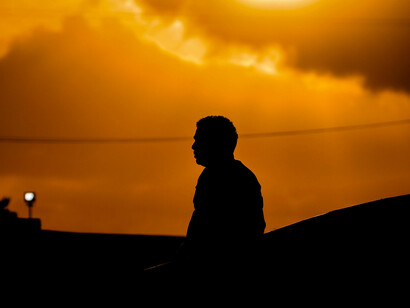 Una persona de perfil durante el atardecer