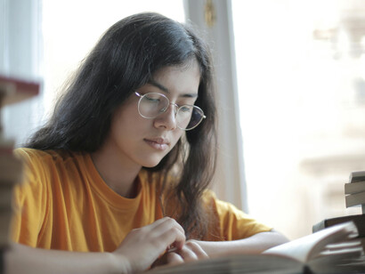 A weary female student with a headache, overwhelmed by mental strain