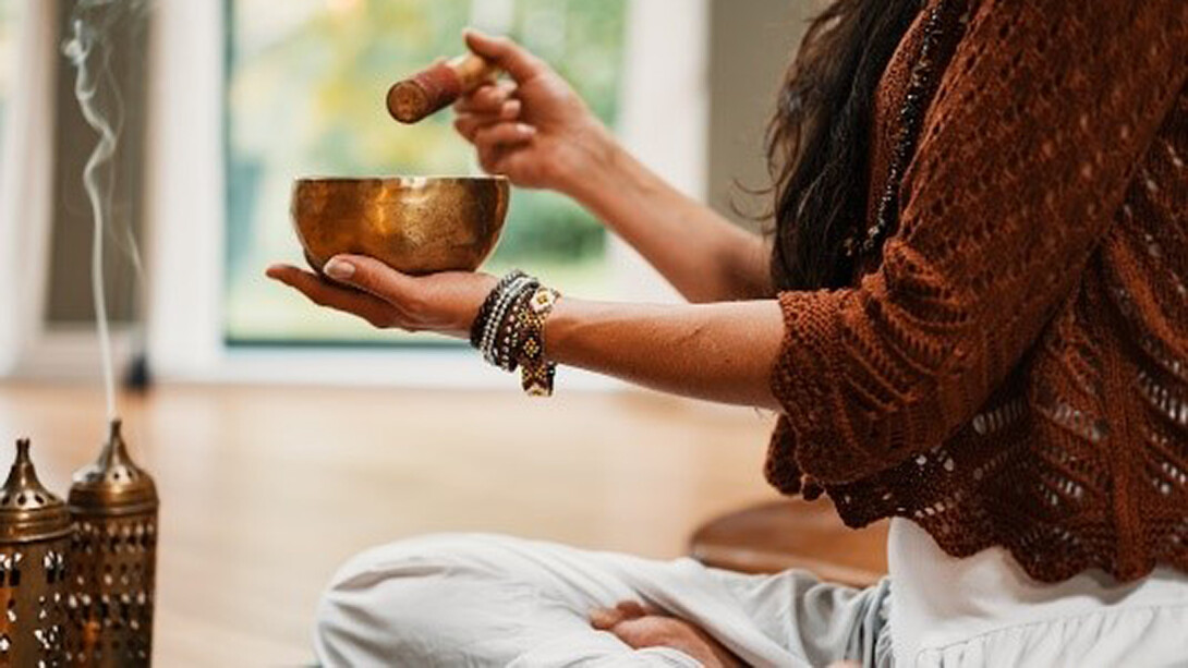 Woman in brown knit sweater holding brown ceramic cup making musical notes