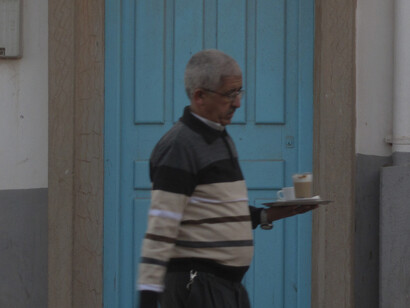 Amidst the quaint ambiance of Tan-Tan's streets, locals pass by in a leisurely manner, adding to the city's relaxed atmosphere