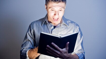 Joven deslumbrado por el libro que está leyendo