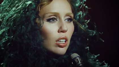 Miley Cyrus in the Something Beautiful video, portraying a powerful moment of self-reflection and artistic rebirth