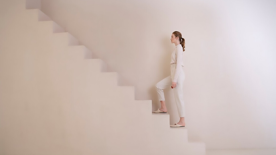 A woman climbing endless stairs, symbolizing the ongoing journey of personal growth and development