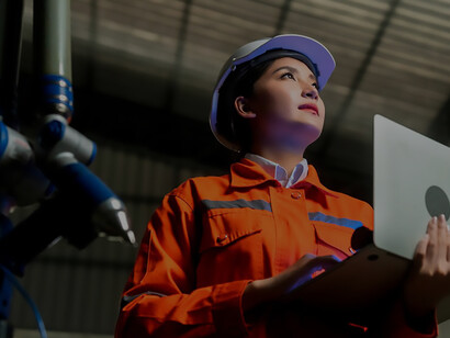 Maximize efficiency and quality control: Asian female engineer specialist and technician maintenance utilize laptops to inspect and oversee relay robot arm systems, ensuring optimal performance