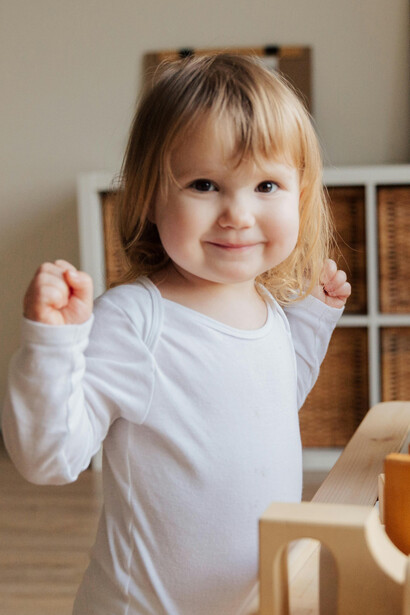 Momento de aprendizado: menina de 3 anos se concentra ao montar brinquedo educativo, ilustrando a relação entre afetividade e habilidades motoras